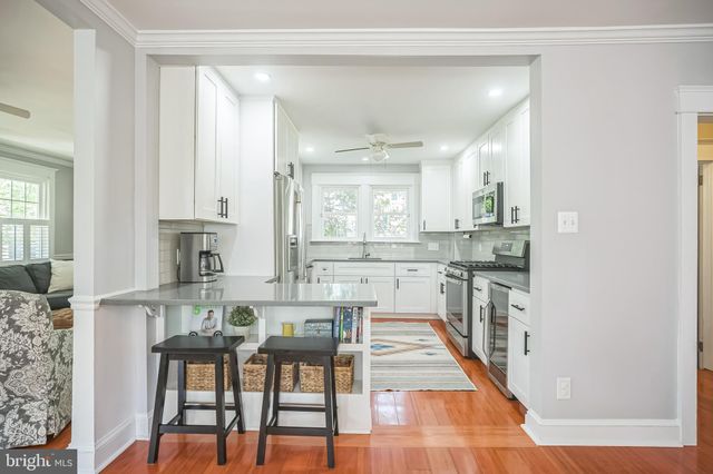 a dining hall with stainless steel appliances kitchen island granite countertop a dining table and chairs