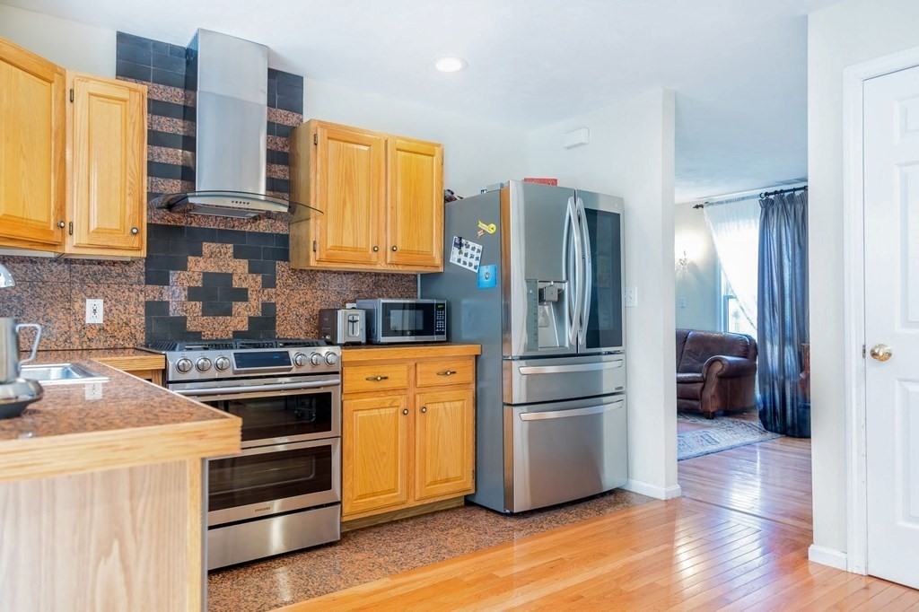 8 Spinney Path Lynn, MA 01902 - Photo 4 of 42 a kitchen with stainless steel appliances and wooden cabinets