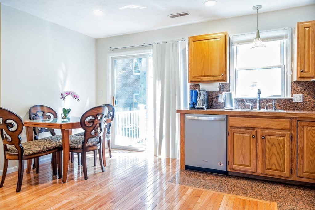 8 Spinney Path Lynn, MA 01902 - Photo 5 of 42 a kitchen with stainless steel appliances granite countertop a dining table chairs a sink and dishwasher a refrigerator with wooden floor