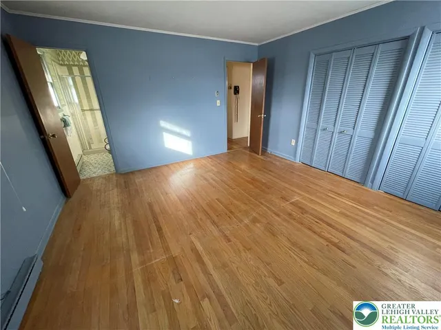 a view of an empty room with wooden floor