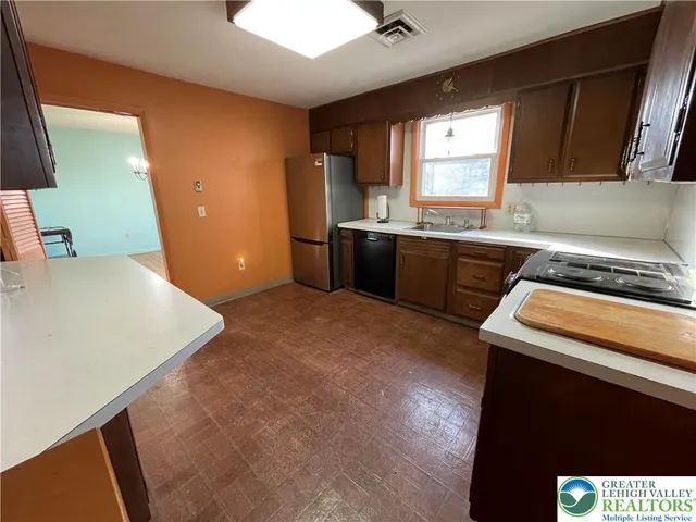 a kitchen with a sink a stove and cabinets