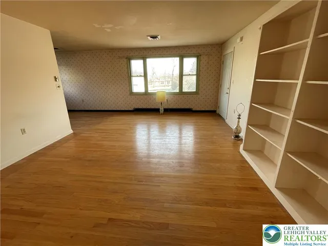 a view of a room with wooden floor and window