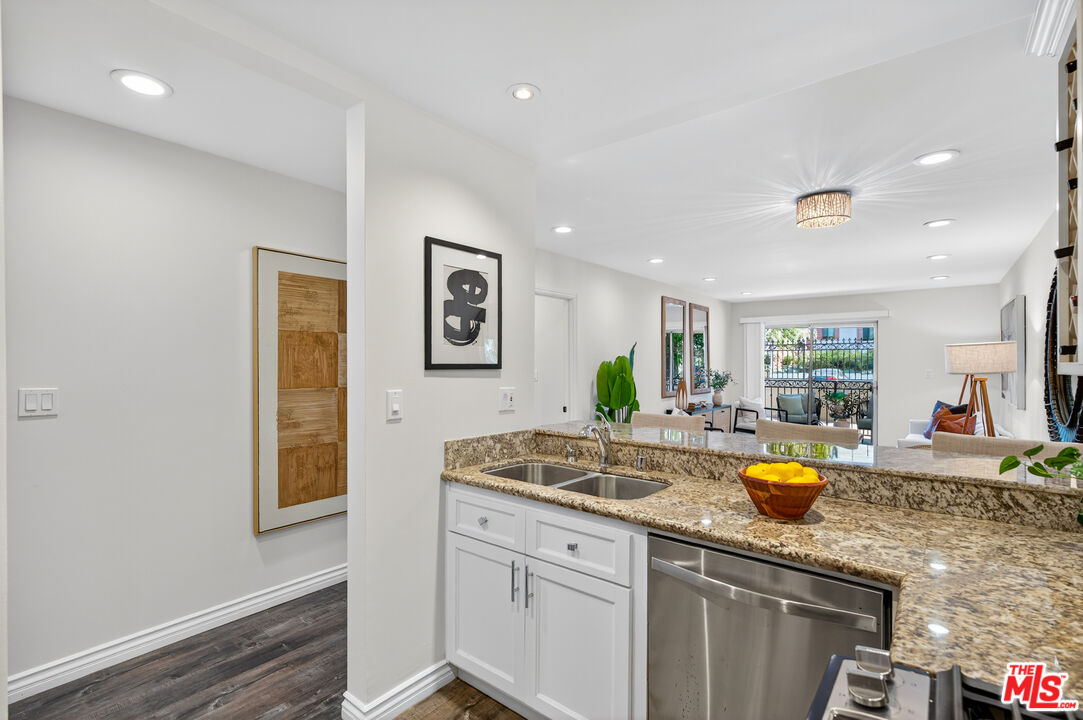 1125 Pico Boulevard, Unit 103 Santa Monica, CA 90405 - Photo 11 of 33 a kitchen with stainless steel appliances granite countertop a sink and a wooden cabinets