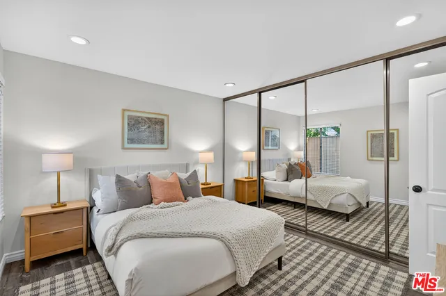 a spacious bedroom with a bed and glass walk in closet