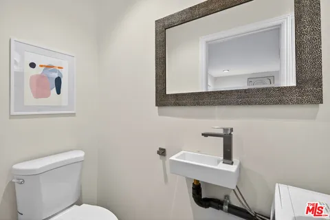 a bathroom with a toilet a sink and mirror