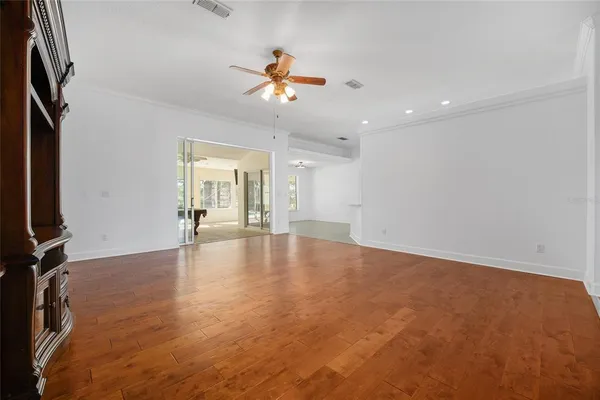 a bedroom with a large bed a flat tv screen and a chandelier