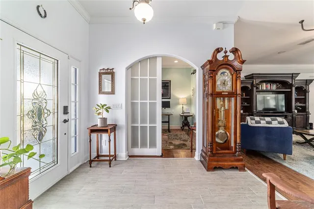 a bedroom with a bed chandelier and a window