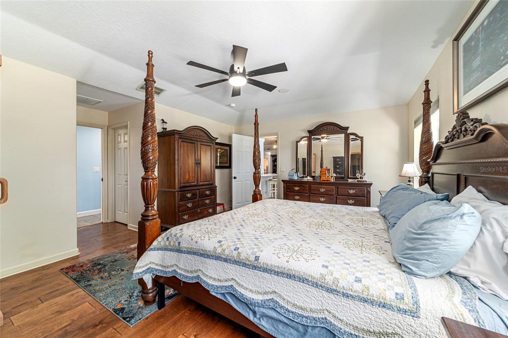 16050 Northwest 10th Circle Citra, FL 32113 - Photo 35 of 71 a bedroom with a large bed a flat tv screen and a chandelier