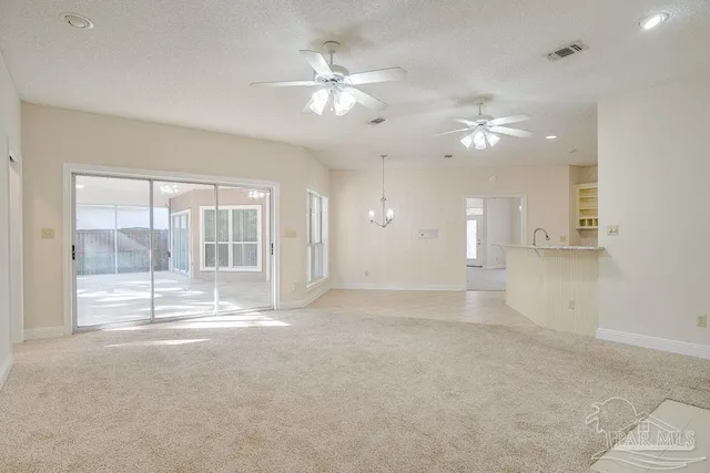 an empty room with a window and ceiling fan