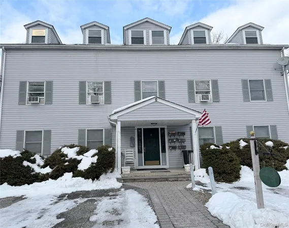 a front view of a house with large windows and potted plants