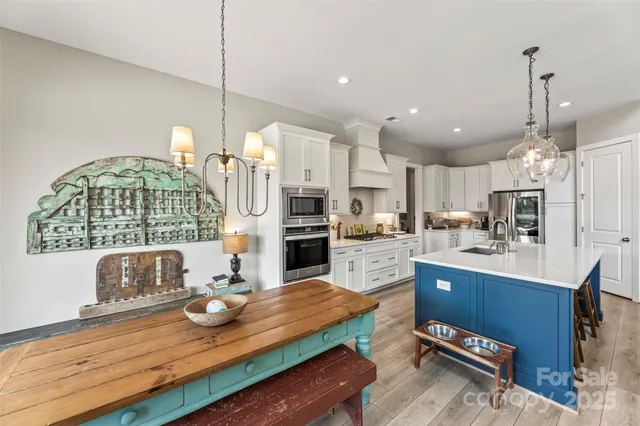 a open kitchen with kitchen island granite countertop wooden cabinets and stainless steel appliances