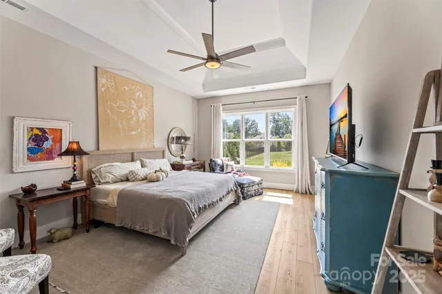 a bedroom with a bed wooden floor and window