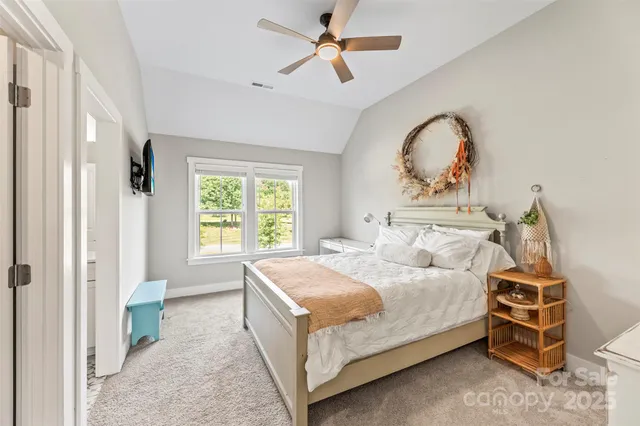 a bedroom with a bed a chandelier and a window