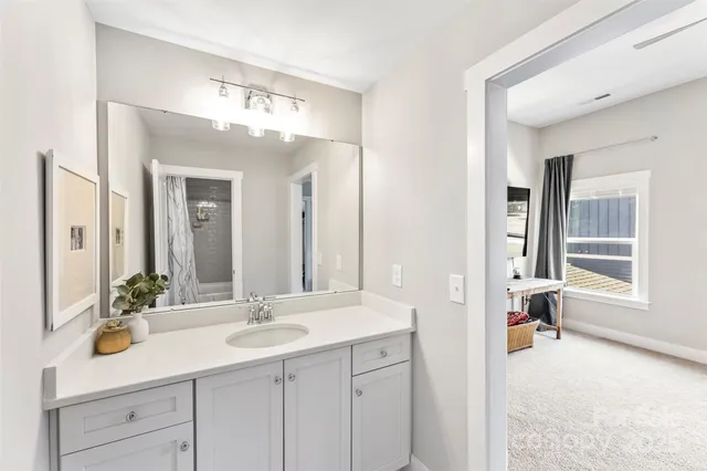 a en suite bathroom with a sink double vanity and a mirror