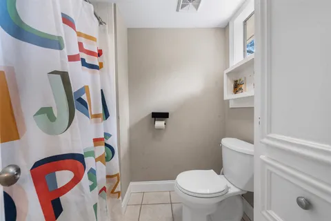 a white toilet sitting next to a bathroom sink and a mirror