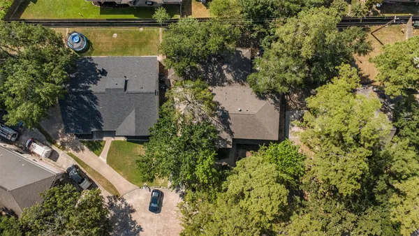 an aerial view of a house with swimming pool and garden