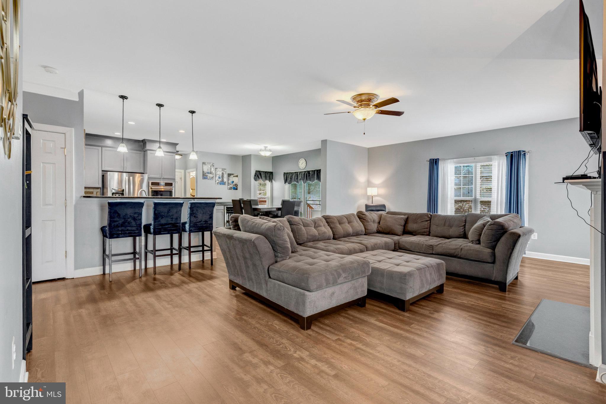 4169 Agency Loop Triangle, VA 22172 - Photo 7 of 56 a living room with furniture a wooden floor and a view of kitchen