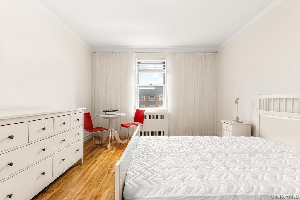 100-10 67th Road, Unit 6L Queens, NY 11375 - Photo 23 of 26 a bedroom with a bed and wooden floor