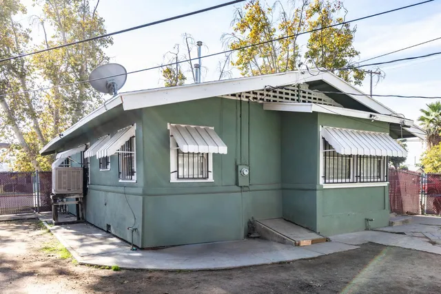a view of a house with a patio and a yard