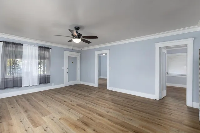 a view of an empty room with wooden floor