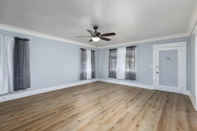 a view of an empty room with wooden floor
