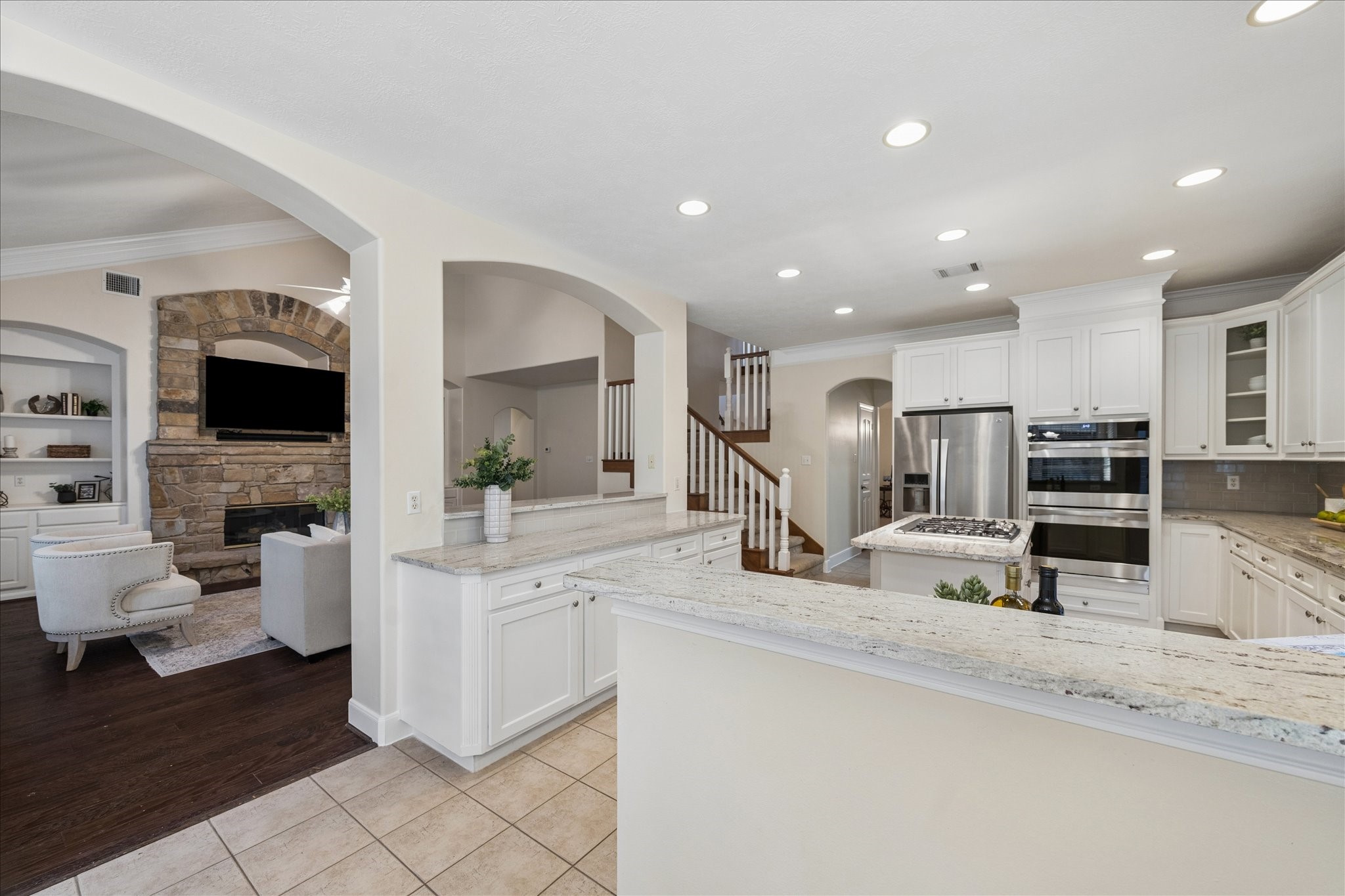 14530 Millhouse Road Pinehurst, TX 77362 - Photo 16 of 46 Another view of the kitchen highlighting the open-concept layout with sightlines to the living room and staircase, ideal for connected everyday living and entertaining.