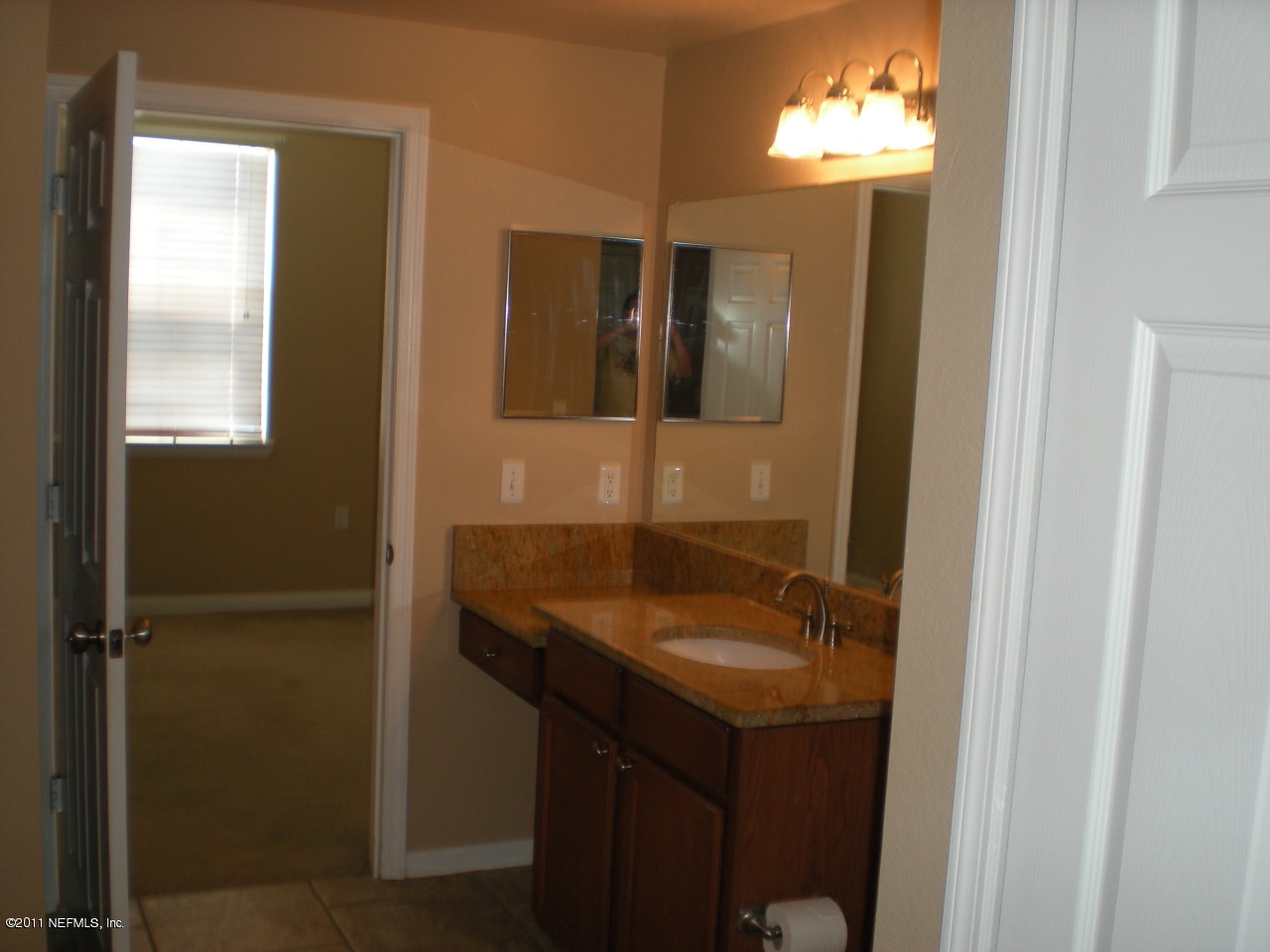 8550 Touchton Road, Unit 1424 Jacksonville, FL 32216 - Photo 5 of 5 a bathroom with a granite countertop sink a mirror and window