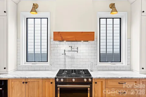 a kitchen with a stove a sink and a window