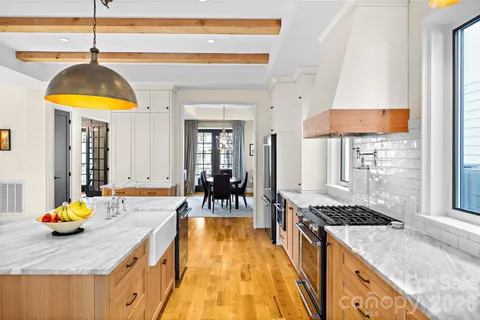 a kitchen with a sink a stove and chairs