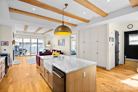 a kitchen with a stove and a view of living room