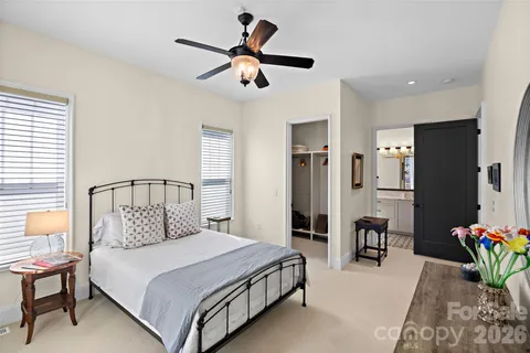 a bedroom with a bed chandelier and a window