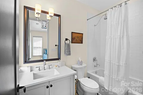 a bathroom with a sink vanity mirror and toilet