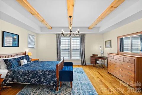 a large bedroom with a bed and wooden floor