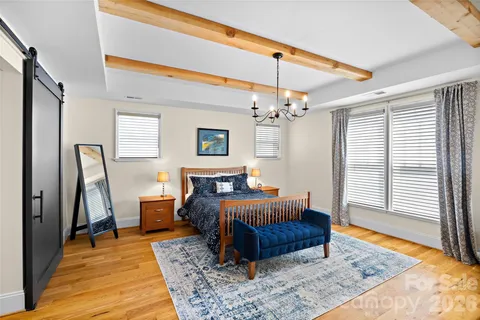 a living room with a bed furniture and a chandelier