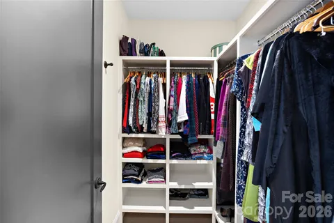 a view of walk in closet with clothes and shoes