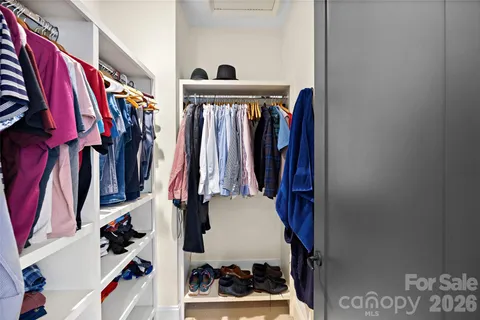 a view of walk in closet with clothes and shoes