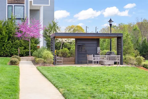 a view of a chair and table in the garden front of house