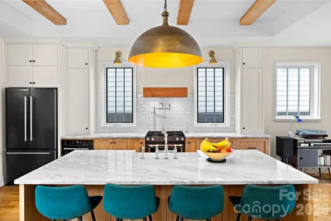 a kitchen with stainless steel appliances granite countertop a stove a sink and a refrigerator