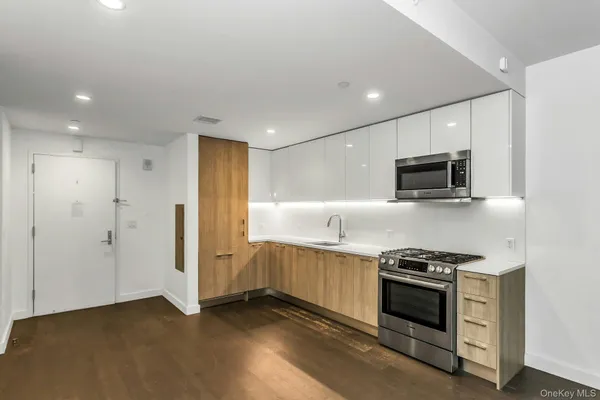 a kitchen with stainless steel appliances a stove microwave and sink