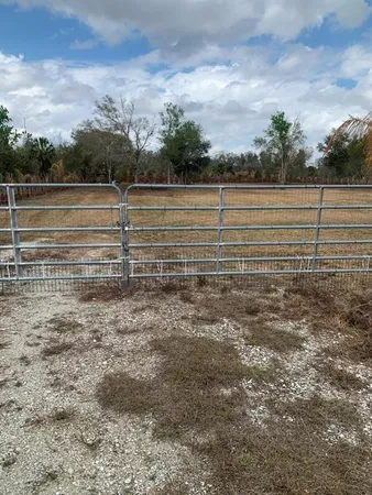 a view of a garage with a table and chairs under an umbrella