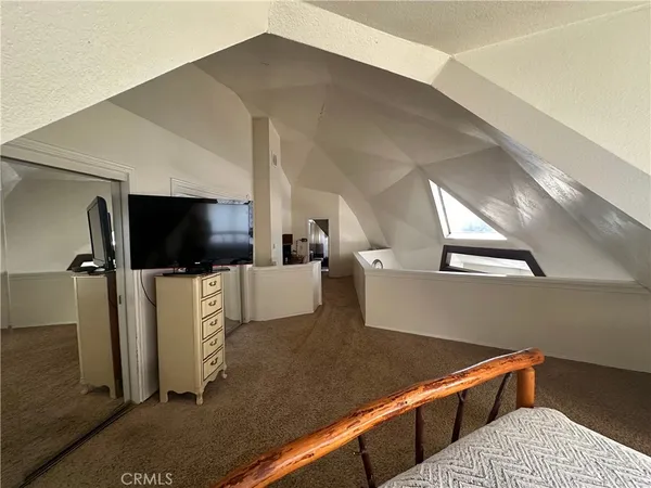 a living room with a flat screen tv and kitchen view