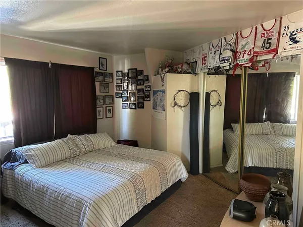 a bedroom with a bed and a refrigerator