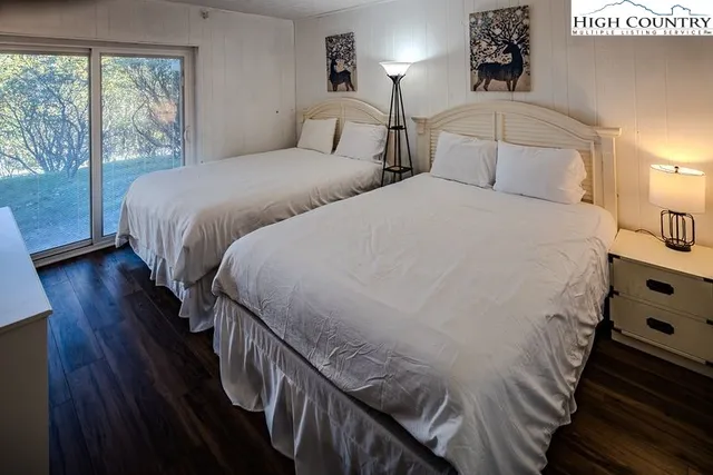 a large white bed in a bedroom next to a window