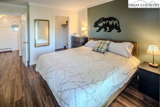 a bedroom with a bed and wooden floor