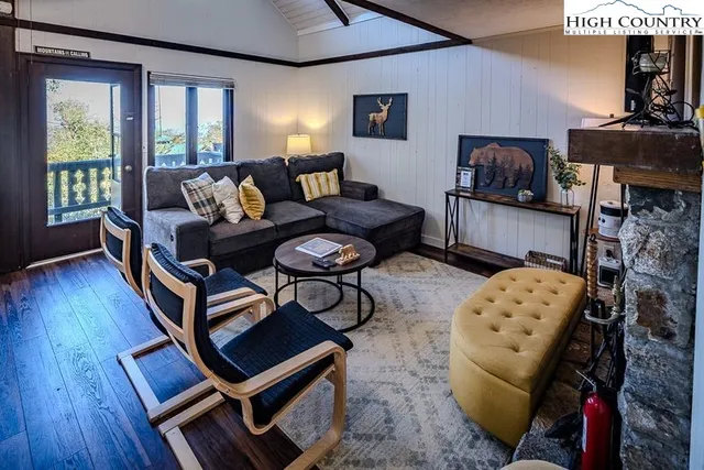 a living room with furniture a wooden floor and a large window