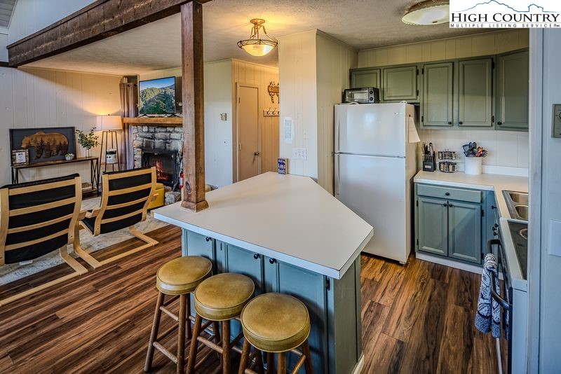 115 North Pinnacle Ridge Road, Unit 47 Beech Mountain, NC 28604 - Photo 10 of 33 a kitchen that has stainless steel appliances a table chairs and a refrigerator