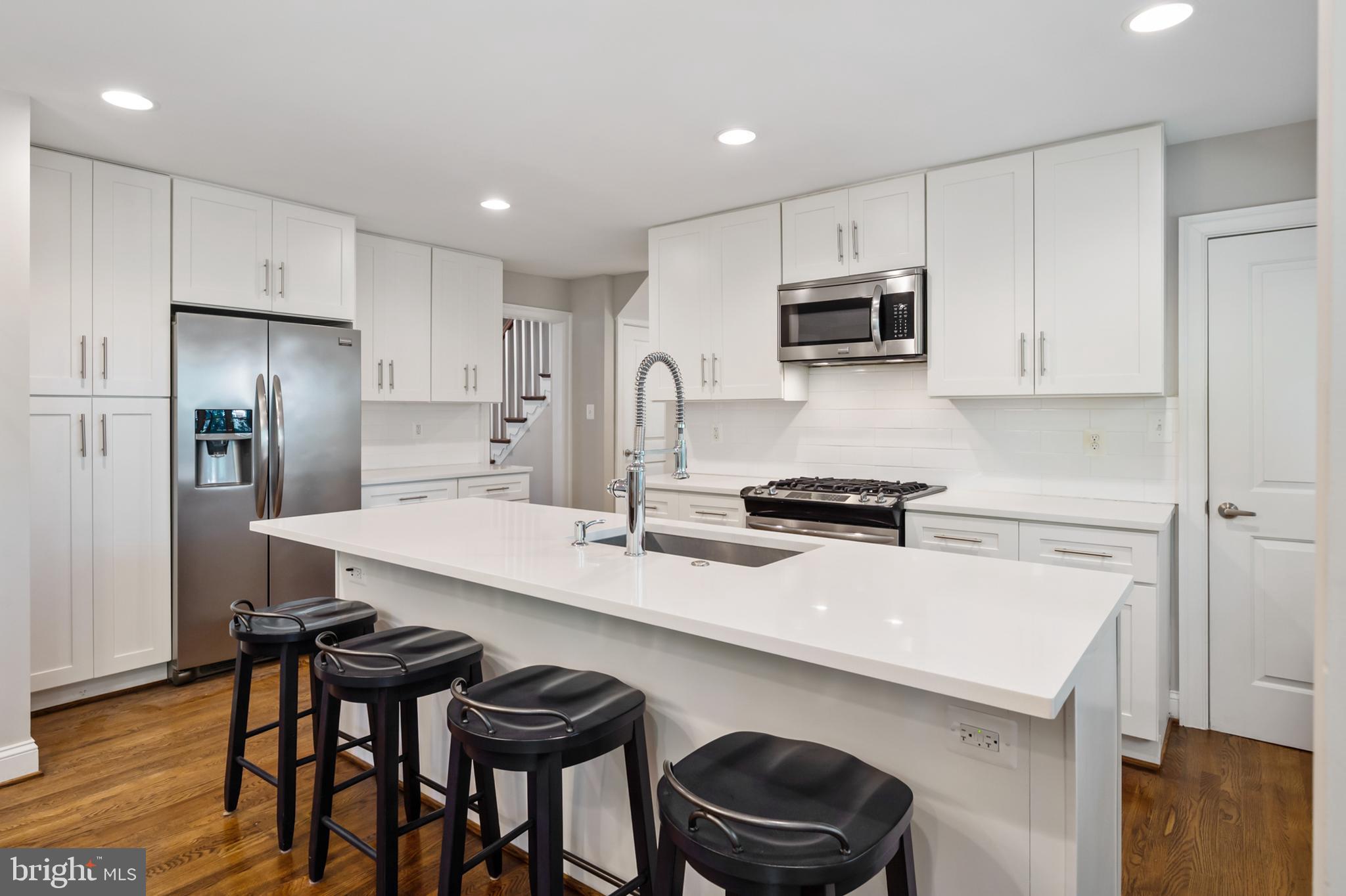 a kitchen with stainless steel appliances a sink a stove a refrigerator and cabinets