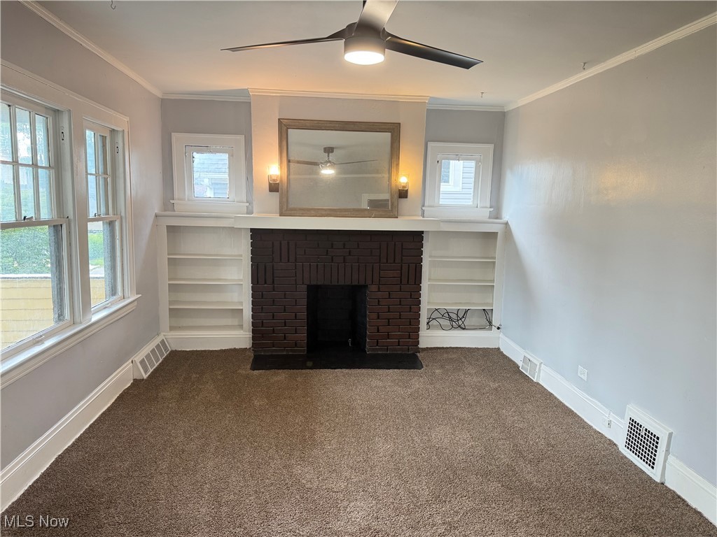 417 Arbor Road Cleveland, OH 44108 - Photo 2 of 20 Unfurnished living room with carpet flooring, a brick fireplace, and ornamental molding