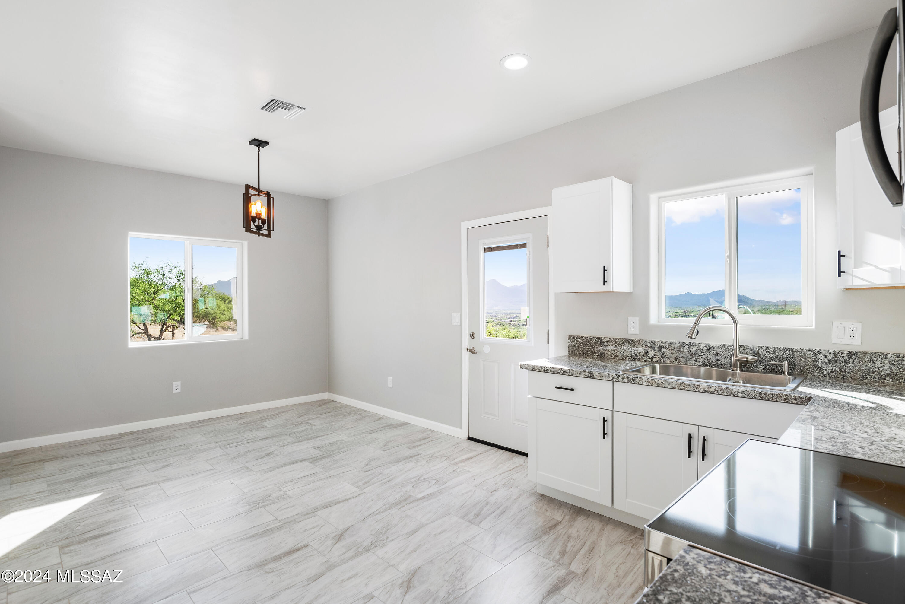 162 Camino Embarcadero Rio Rico, AZ 85648 - Photo 21 of 35 a kitchen with stainless steel appliances granite countertop a sink cabinets and wooden floor