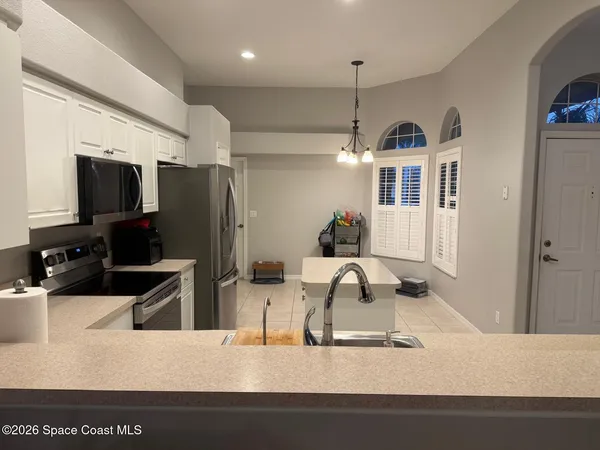 a kitchen with stainless steel appliances kitchen island granite countertop a refrigerator a stove and a sink with wooden floor
